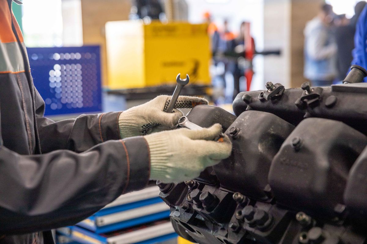 Close-up of a mechanic using a wrench to work on an engine
