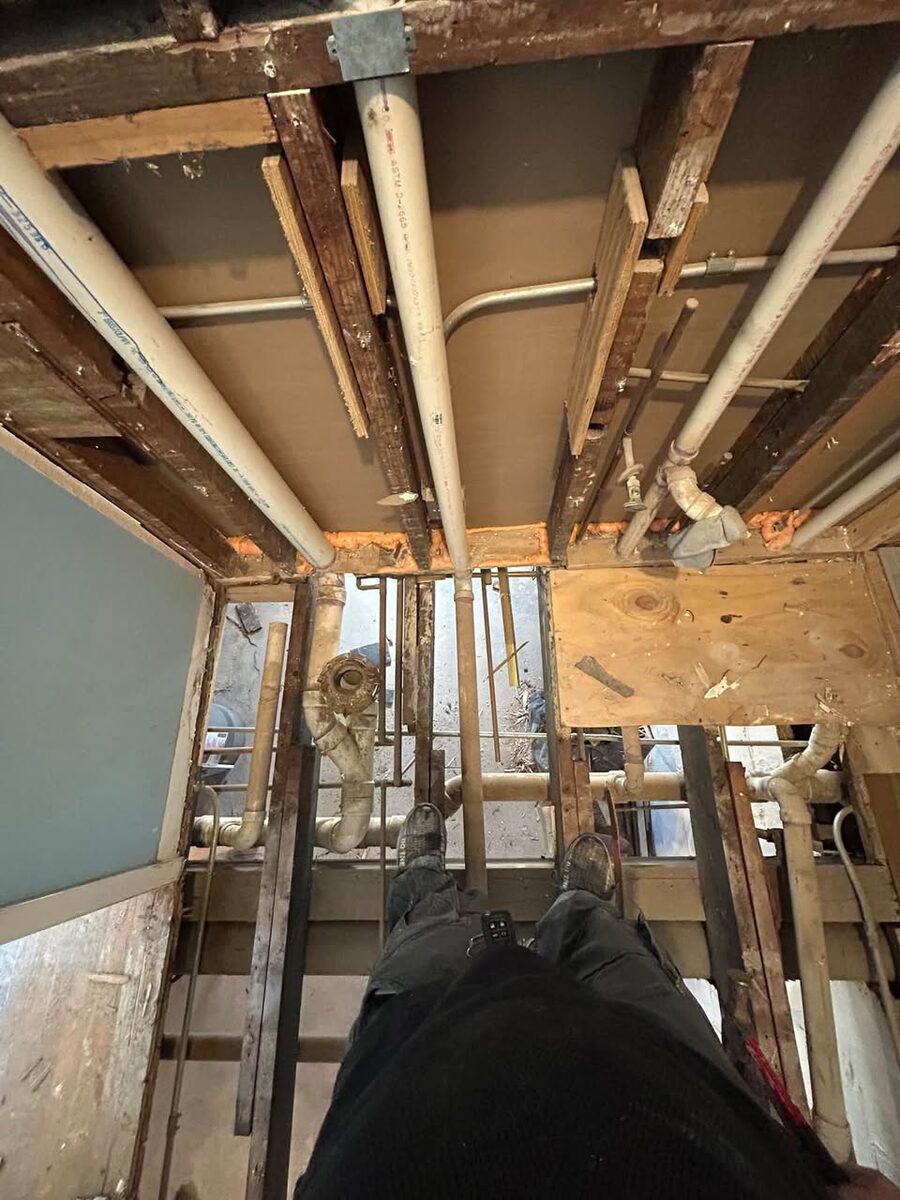 Exposed framing and plumbing during an interior home repair
